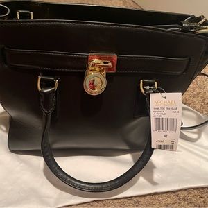 Brand new.Very light mark next to the MK logo.Very hard to see.